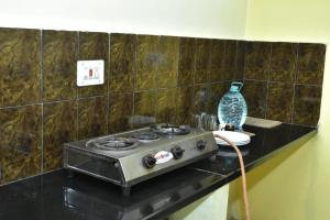 a stove sitting on a counter in a room at Eshwari Cottage in Madikeri