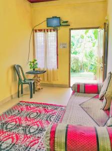 ein Wohnzimmer mit Sofa und Tisch in der Unterkunft Eshwari Cottage in Madikeri