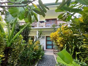 um edifício com um monte de plantas em frente dele em Fat Lips Surf Lodge em General Luna