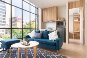 a living room with a blue couch and a table at Silom Nara in Bangkok