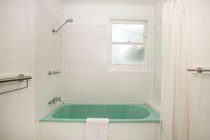 a bath tub in a white bathroom with a window at Jack's Culburra - Absolute Waterfront with Fireplace in Culburra Beach +24 photos