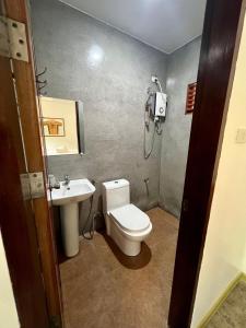 uma casa de banho com um chuveiro, um WC e um lavatório. em Fat Lips Surf Lodge em General Luna