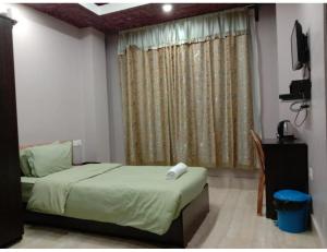 シロンにあるMontis Stay, Shillongのベッドルーム1室(ベッド1台付)、窓(テレビ付)