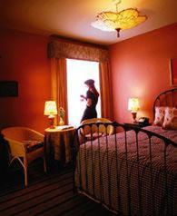 a woman standing in front of a bed in a bedroom at Hotel Boheme in San Francisco