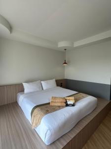 1 dormitorio con 1 cama blanca grande con almohadas blancas en Diamond Park Inn Chiangrai & Resort, en Chiang Rai
