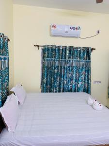 a bedroom with a white bed with a air conditioner on the wall at KHOLA HAWA GUEST HOUSE in Bolpur +21 photos