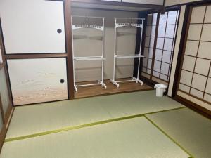 a room with two glass doors and a room with a floor at ゲストハウス アルベルゲ Guesthouse ALBERGUE SAKURA in Sukumo