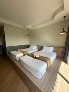 two beds in a hotel room with two bedsvisor at Diamond Park Inn Chiangrai & Resort in Chiang Rai