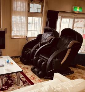 a row of black leather chairs in a living room at SnowHouse Memorie Hotel-石打丸山 in Seki