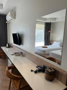 a hotel room with a mirror and a bed at Diamond Park Inn Chiangrai & Resort in Chiang Rai