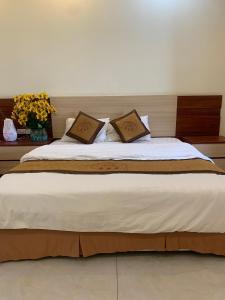1 cama grande con 2 almohadas encima en ĐÔNG THÀNH, en Hòa Ðình
