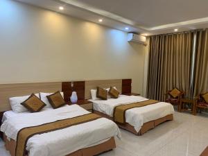 a hotel room with two beds in a room at Đông Thành Hotel in Hòa Ðình