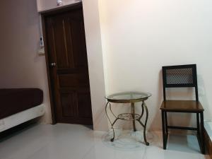a room with a table and a chair and a door at Nature Home in Phra Nakhon Si Ayutthaya