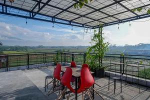 d'une terrasse avec une table et des chaises et une vue. dans l'établissement RedDoorz near Universitas Muhammadiyah Purwokerto 2, à Kembaran