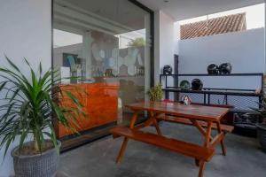 a wooden table and a bench in a room at RedDoorz near Universitas Muhammadiyah Purwokerto 2 in Kembaran