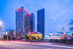 a tall building with red lights in front of it at Hilton Garden Inn Ningbo in Ningbo