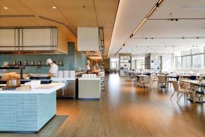 a kitchen with two chefs in a large room at Shanghai Marriott Hotel Pudong East in Shanghai