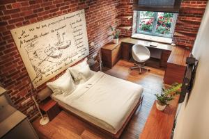 a bedroom with a bed and a brick wall at Apartamenty Straszewskiego in Krakow