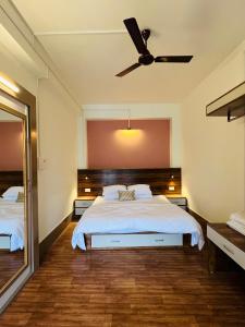 a bedroom with a bed and a ceiling fan at Pink Rose Homestay in Gangtok