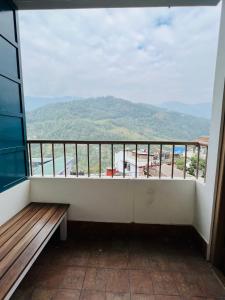 a balcony with a bench and a view of a mountain at Pink Rose Homestay in Gangtok