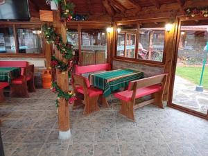 a restaurant with tables and chairs and christmas decorations at Къща за гости "Там край реката " in Slivek