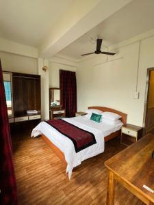 a hotel room with a bed and a table at Pink Rose Homestay in Gangtok