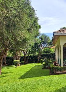 una casa con un patio con césped verde y árboles en Greenview Homes, en Eldoret