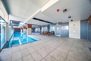 einen Pool in einem großen Gebäude mit Lobby in der Unterkunft Pokémon Inspired Apt -Pool-Gym-Sauna-Steam Room in Adelaide