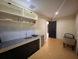 a kitchen with a sink and a counter with a chair at APARTELLE BORACAY in Boracay