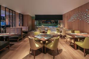 a restaurant with tables and chairs and a bar at Hilton Garden Inn Ningbo in Ningbo