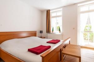 ein Schlafzimmer mit einem Bett mit zwei roten Handtüchern darauf in der Unterkunft Villa Eden Binz Typ 5 (Apt.14) in Binz