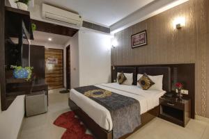 a bedroom with a bed and a television in it at Hotel Venus Plaza in New Delhi