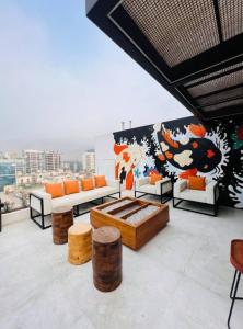 una sala de estar con muebles de color naranja y blanco y un mural en Estreno Depa frente CC El polo, en Lima