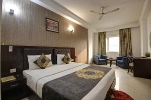 ein Hotelzimmer mit einem großen Bett in einem Zimmer in der Unterkunft Hotel Venus Plaza in Neu-Delhi