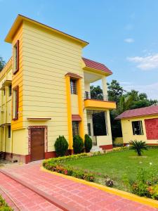 una casa amarilla con una entrada delante de ella en KHOLA HAWA GUEST HOUSE en Bolpur