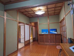 a room with wooden floors and a room with glass walls at 龍のお宿 in Nio