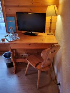 einen Holzschreibtisch mit Monitor und Stuhl in der Unterkunft La Tour d'Aï in Leysin