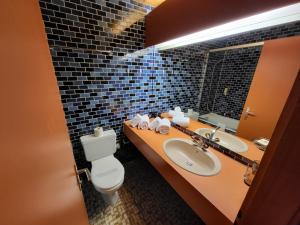 a bathroom with two sinks and a toilet and a mirror at La Tour d'Aï in Leysin
