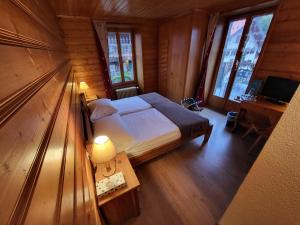 a bedroom with a bed and a desk and windows at La Tour d'Aï in Leysin