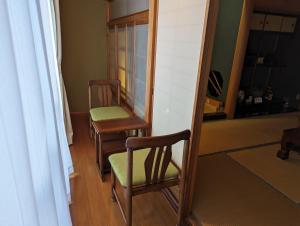 due sedie e uno specchio in una stanza di 龍のお宿 
