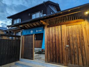 a house with wooden gates in front of it at 龍のお宿 in Nio