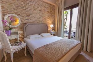 a bedroom with a bed and a brick wall at Hotel Galini in Limenas