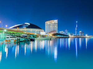 福冈Rakuten STAY Fukuoka Yakuin Family Room的夜晚的城市天际线与水体