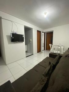 - un salon avec un canapé et une télévision murale dans l'établissement Temporada CG - Apartamento no Alto Branco, à Campina Grande