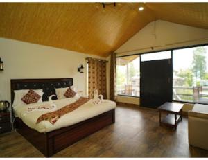 - une chambre avec un grand lit et une grande fenêtre dans l'établissement Paradise kabins, srinager J&K, à Telbal