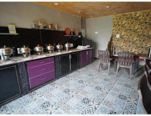 une cuisine avec des placards violets, une table et des chaises dans l'établissement Paradise kabins, srinager J&K, à Telbal