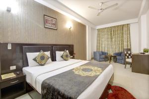 a hotel room with a bed and a dining room at Hotel Venus Plaza in New Delhi