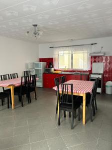 a kitchen with red cabinets and a table and chairs at PENSIUNEA KELEMEN in Praid