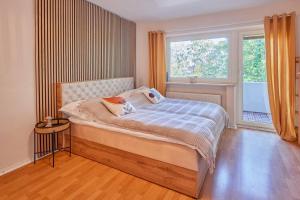a bedroom with a bed and a large window at *Design Studio nahe Frankfurt Bahnhof & Flughafen* in Neulsenburg