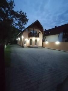 une maison avec des lumières sur le côté d'une allée dans l'établissement PENSIUNEA KELEMEN, à Praid